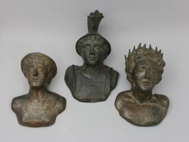 Ces trois bustes d’applique en bronze représentent trois divinités romaines : Mercure coiffé d'un pétase, Minerve d'un casque et Sol d'un diadème rayonnant. 
